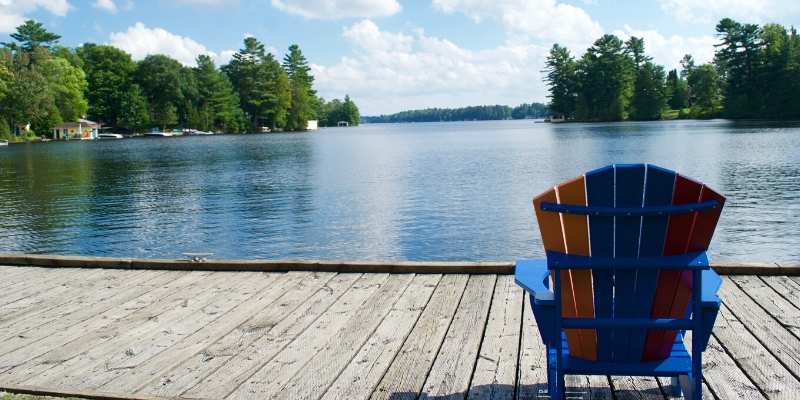 muskoka chair on dock overlooking lake