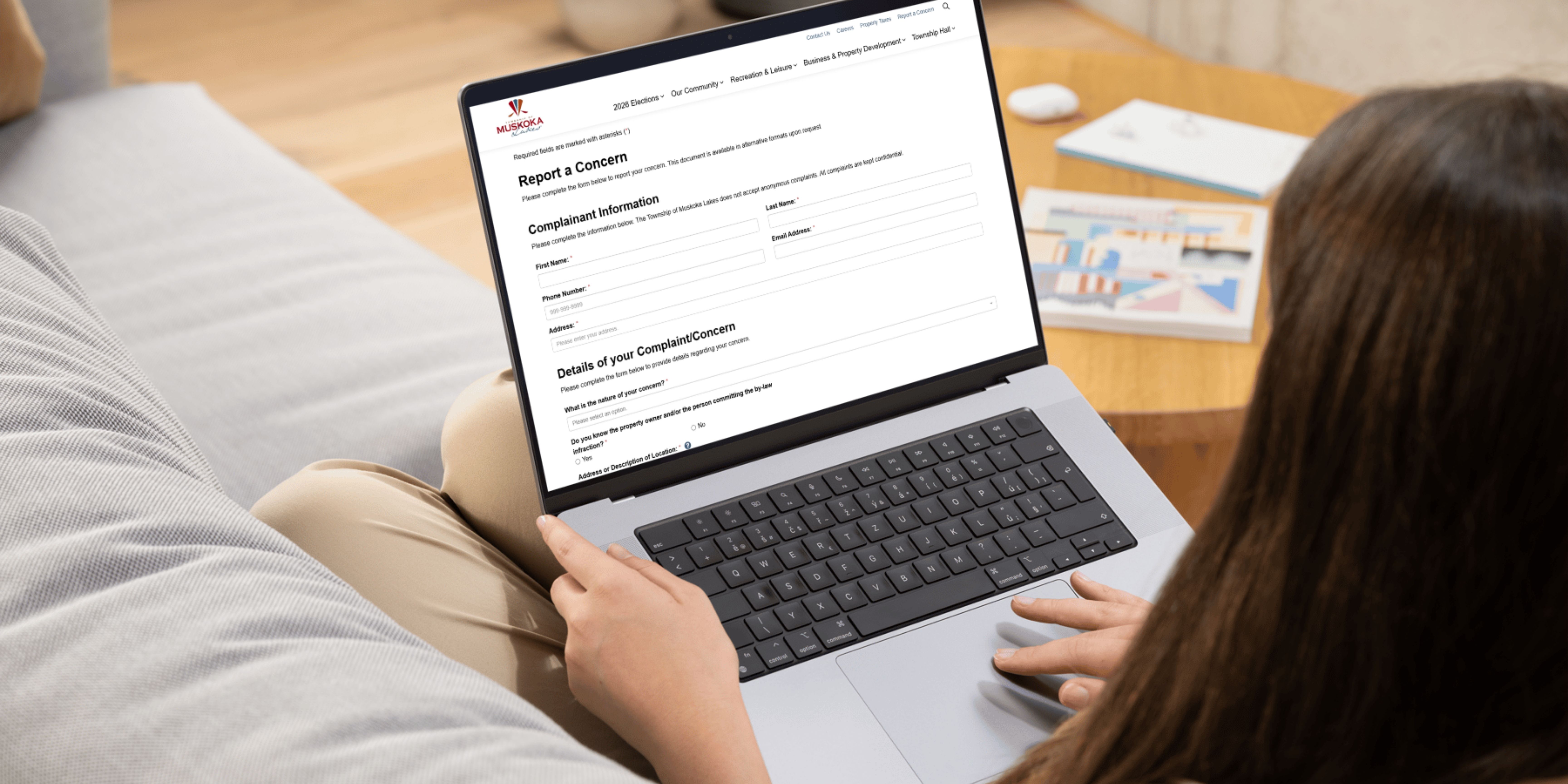 Person using laptop, on report a concern form webpage