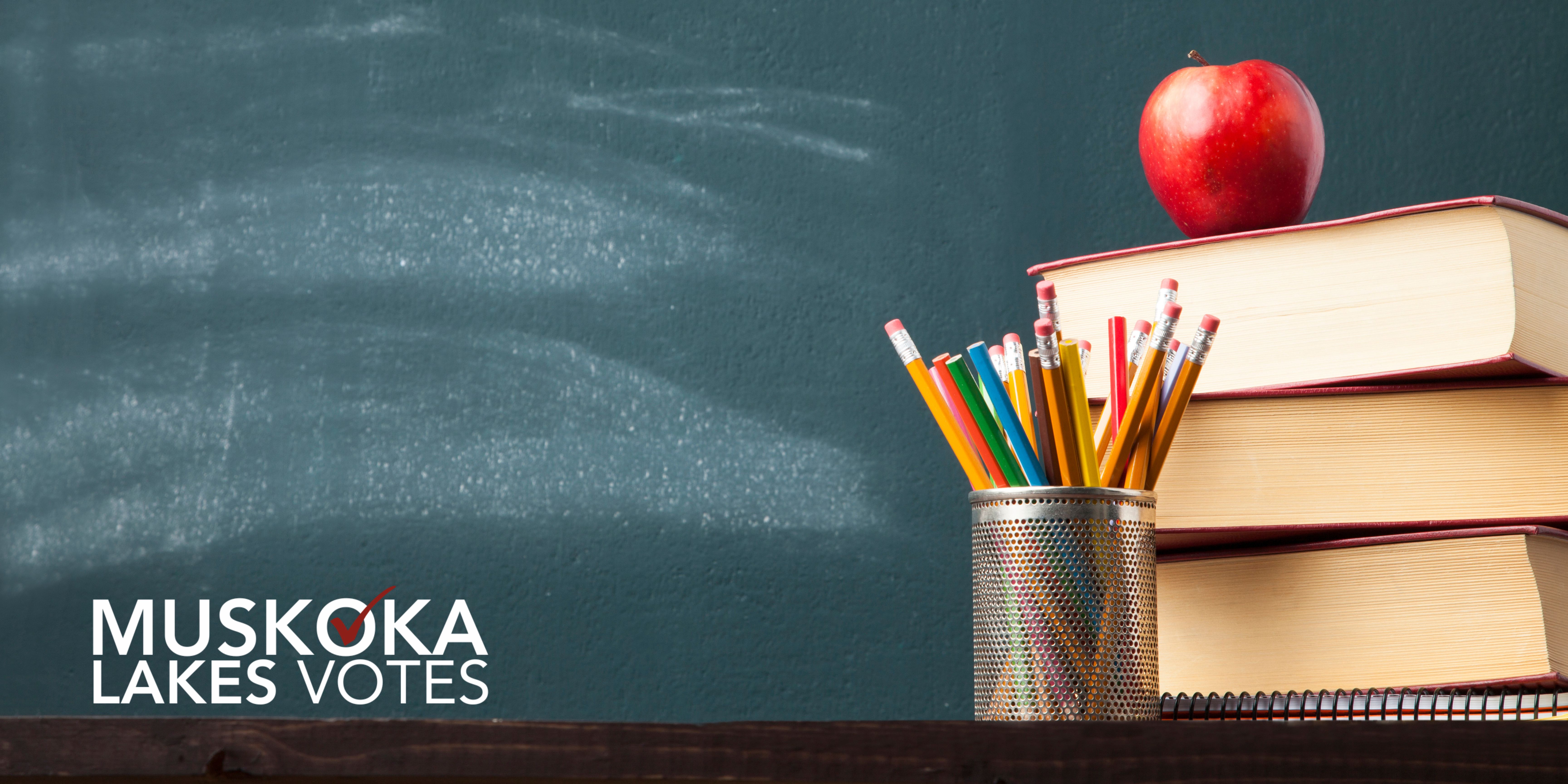 blackboard behind a stack of books with the muskoka lakes votes logo