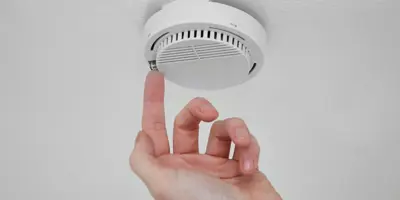 Finger pressing smoke alarm