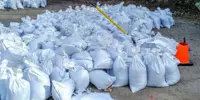 A large pile of sandbags being prepared