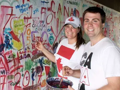 Two people painting a wall and smiling