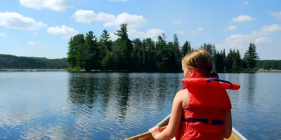 person sitting in canoe with life jacket