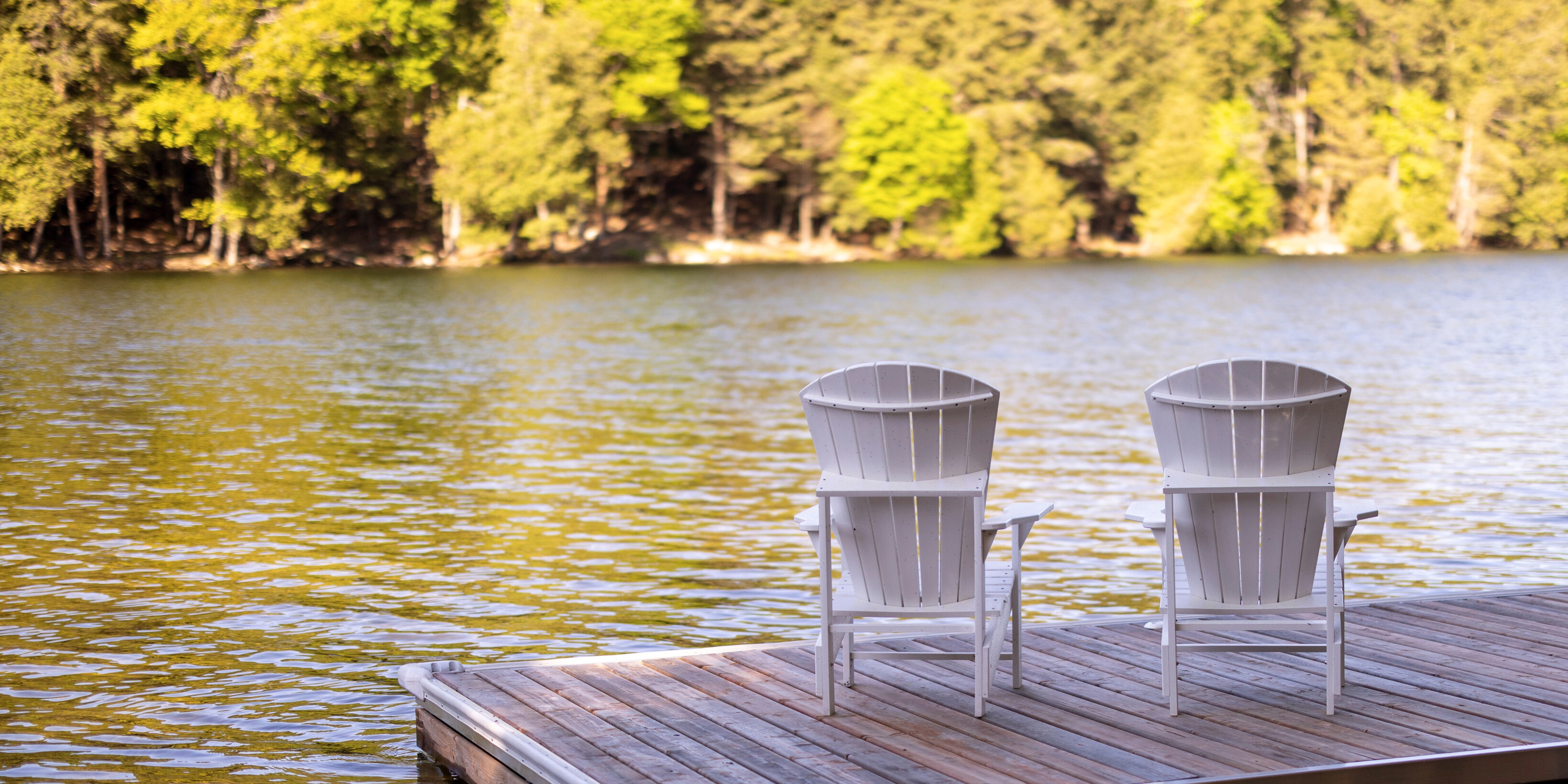 Images of Muskoka chairs on dock, facing a lake and trees