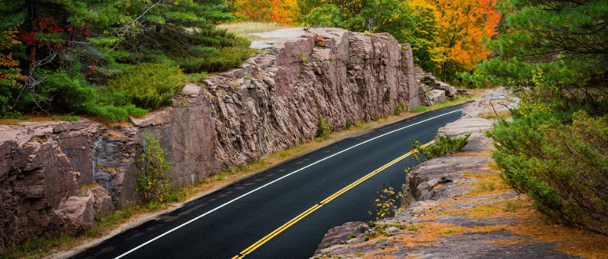 Road running through a rocky outcropping in autumn