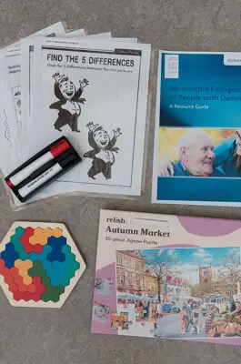 Contents of cognitive care kit; dry erase markers, laminated activity sheets, colourful wooden puzzle, jigsaw puzzle and a resource guide.