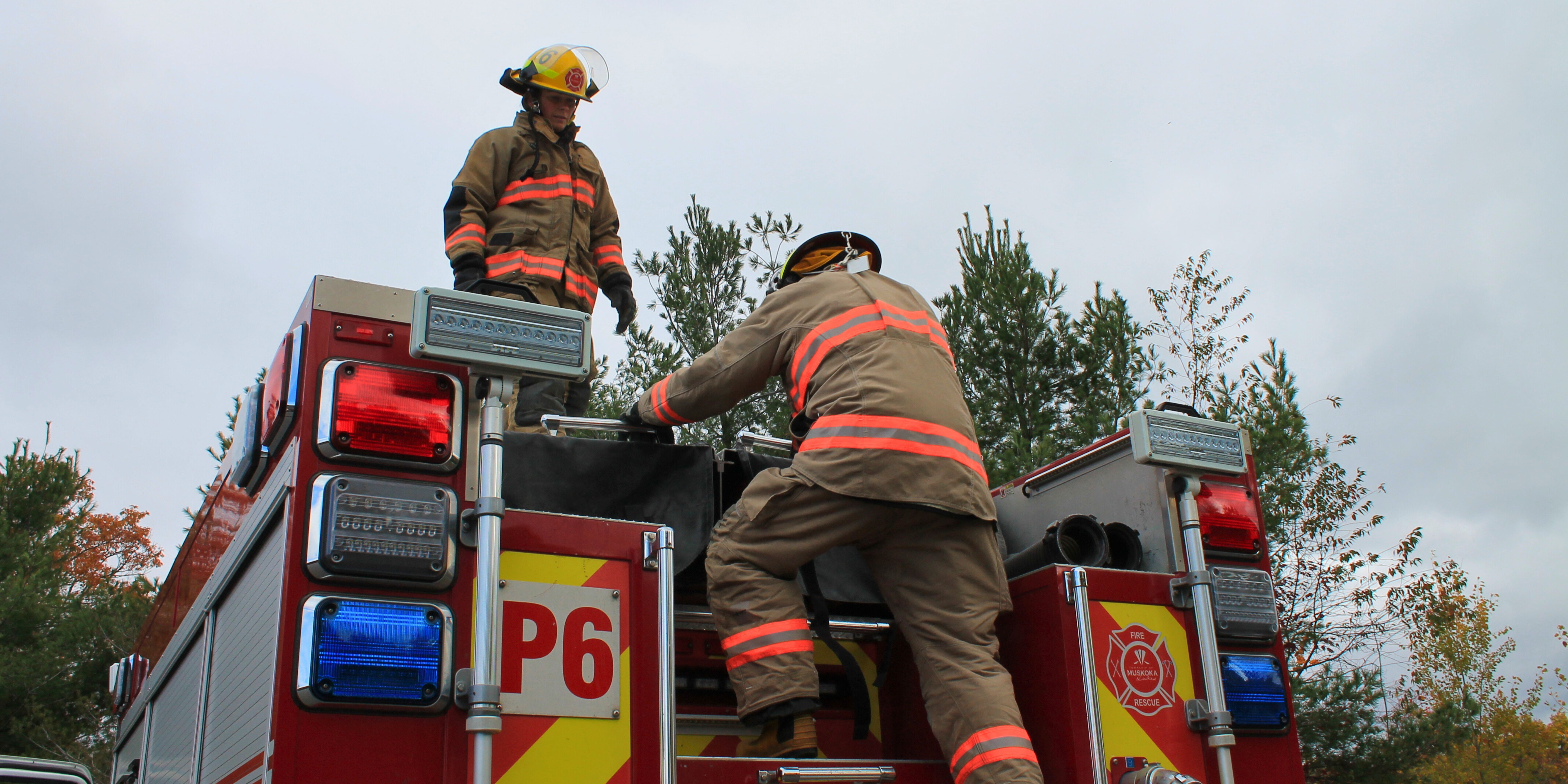 Firefighters climbing on truck