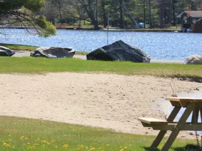 A picnic table in the grass beside a beach