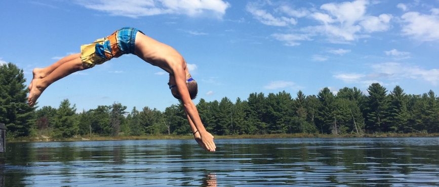 A kid diving into the lake